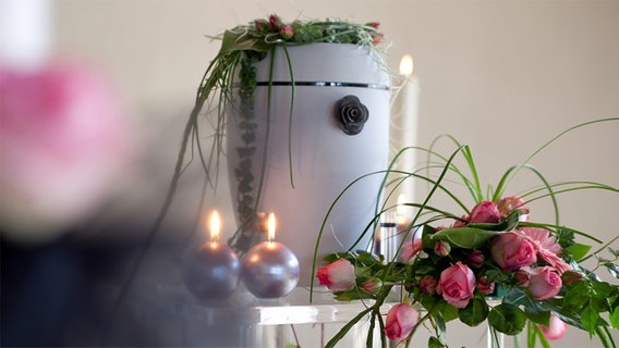 Eine Urne steht auf einem mit Blumen geschmückten Tisch. © Bundesverband Deutscher Bestatter 