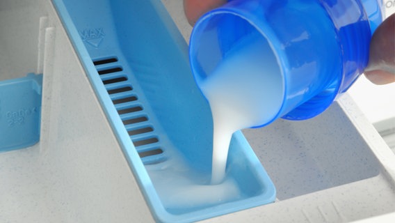 Flüssigwaschmittel wird in eine Waschmaschine gefüllt. © Colourbox Foto: -