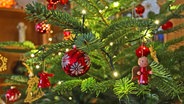 An den Zweigen eines Weihnachtsbaums hängt Weihnachtsschmuck. © imago images Foto: Rene Traut