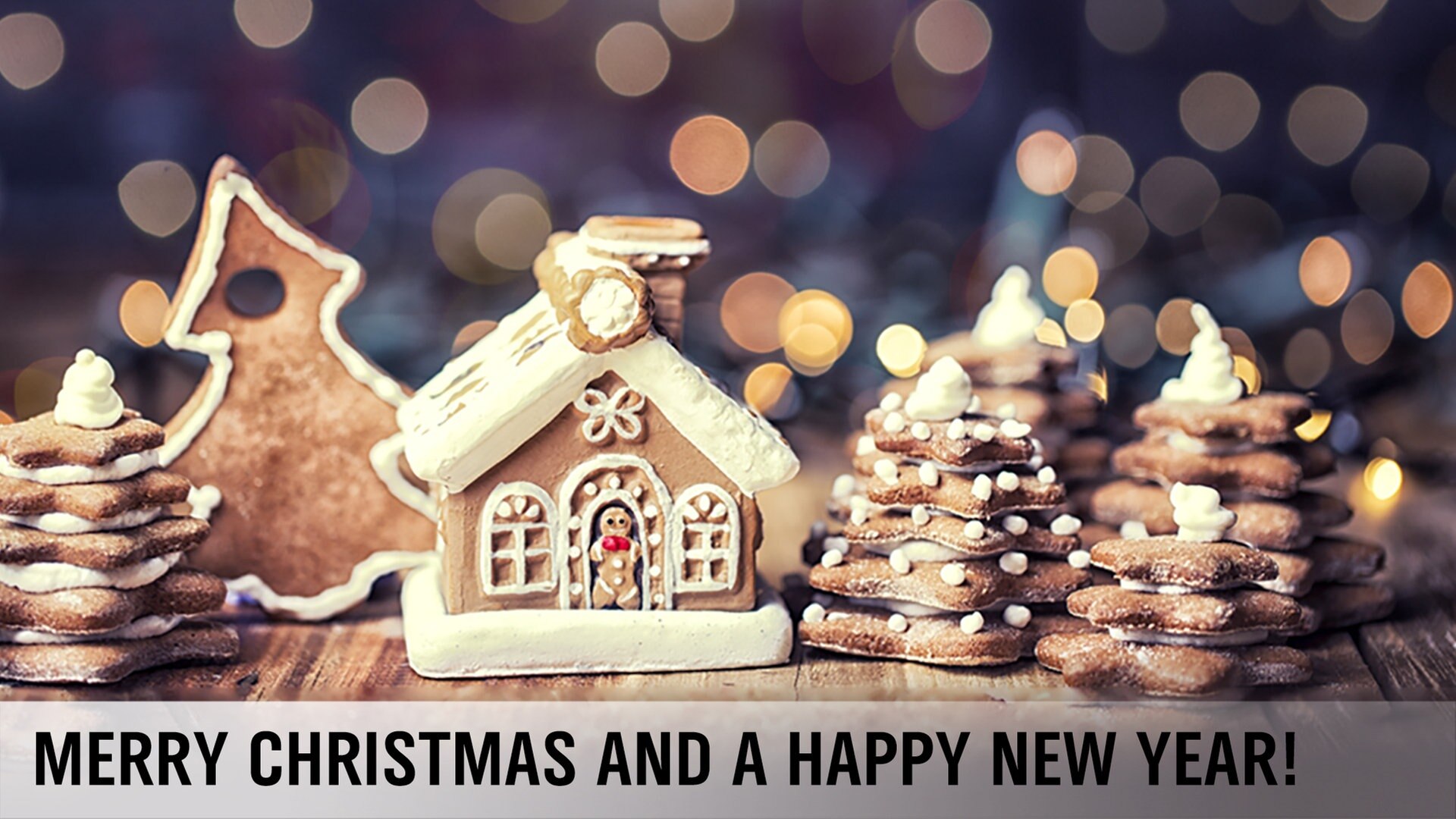 Zu Weihnachtsbäumen gestapelte Kekse und ein kleines Lebkuchenhaus stehen auf einem Tisch. © Fotolia Foto: Drubig