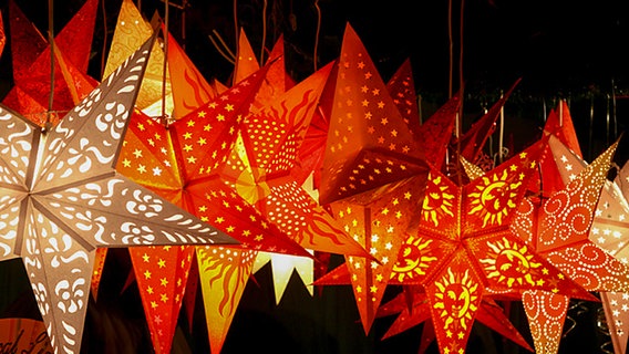 Lampenschirme in Sternform auf einem Weihnachtsmarkt. © NDR Foto: Ulla Brauer