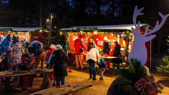 Ein Stand und Besucher bei der Waldweihnacht im ErlebnisWald Trappenkamp © ErlebnisWald Trappenkamp Foto: Ralf Seiler