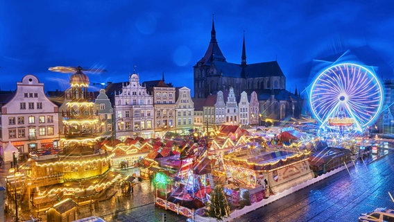 Blick auf den Rostocker Weihnachtsmarkt mit Riesenrad und Pyramide © imago images Foto: Bildwerk