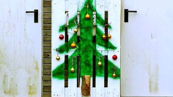 Eine weiße Palette, auf die mit grüner Farbe ein Weihnachtsbaum aufgesprüht wurde © Imago Foto: Shotshop