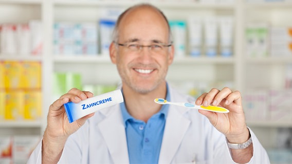 Apotheker mit Zahnbürste und Zahnpasta © fotolia.com Foto: contrastwerkstatt