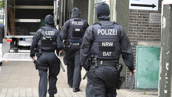 Polizisten durchsuchen ein Gebäude in Düsseldorf als Teil einer Razzia gegen Geldwäsche und Terrorfinanzierung in drei Bundesländern. © dpa Foto: Roberto Pfeil