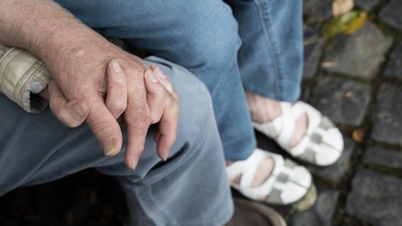 Ein Seniorenpaar hält sich bei den Händen. © photocase Foto: xenias