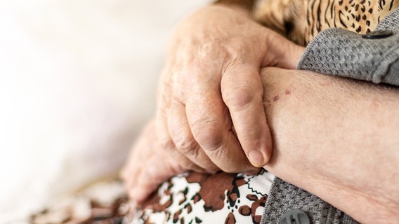 Die vor dem Bauch verschränkten Hände einer älteren Frau © photocase Foto: Brilliant Eye