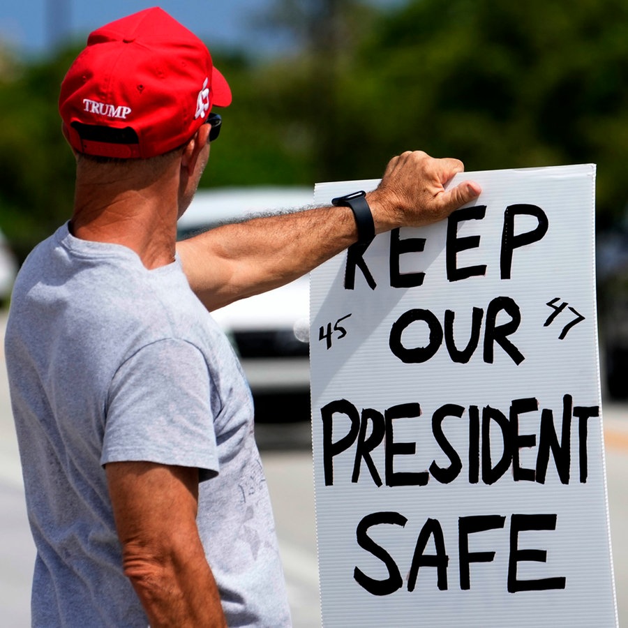 ein Trumpanhänger hält ein Schild in der Hand, auf dem steht: " keep our president safe " © AP Foto: Lynne Sladky
