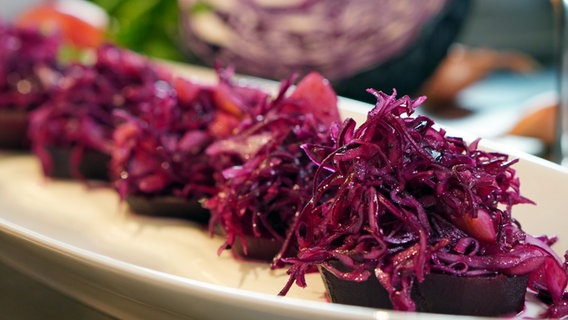 Rote Bete mit Rotkohlsalat auf einer ovalen Platte angerichtet. © NDR Foto: Florian Kruck