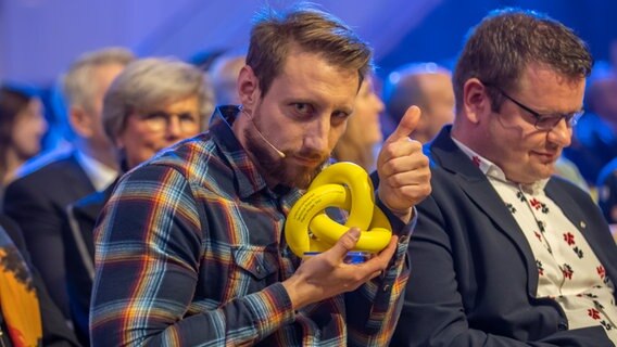 Martin Moder hält den LifeScienceXplained-Preis in den Händen © NDR Foto: Axel Herzig