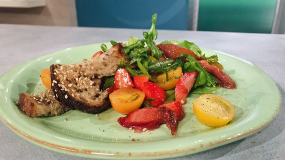 Rhubarb and tomato salad with strawberry vinaigrette arranged on a plate © NDR 