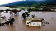 Hochwasser umgibt ein Haus in Kalifornien, nachdem der Salinas River über die Ufer trat. © picture alliance/dpa/AP | Noah Berger Foto: Noah Berger