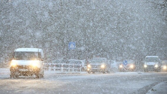 Bei dichtem Schneefall befahren Autos eine Straße in Langenhagen (Niedersachsen). © dpa Foto: Holger Hollemann