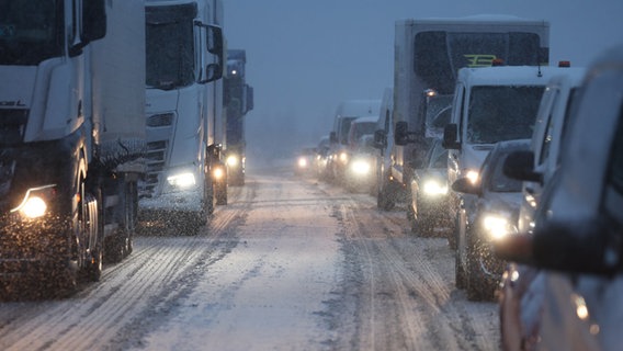 Fahrzeuge fahren Stop-and-go bei Schneefall auf einer Autobahn. © dpa Foto: Bernd Wüstneck