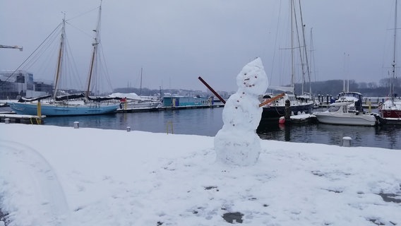 Der Hafen von Travemünde bei Schnee - ein Schneemann im Vordergrund. © NDR Foto: Jörg Grund aus Travemünde