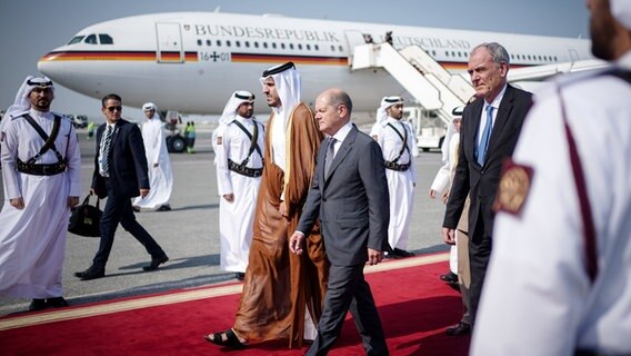 Bundeskanzler Olaf Scholz (SPD) wird auf dem Flughafen von Doha von Mohammed bin Hamad bin Quassim Al Thani, Handels- und Industrieminister des Staates Katar vor dem Airbus A340 der Luftwaffe begrüßt. © dpa Foto: Kay Nietfeld