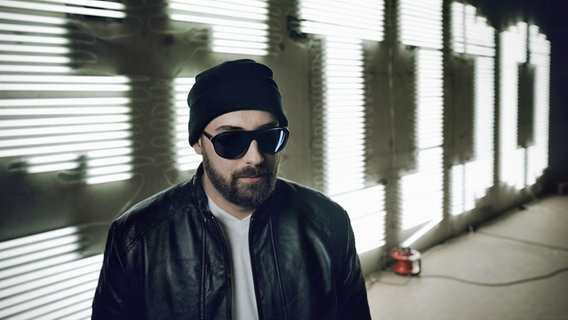 Der deutsche Rapper Sido vor seinem Namenszug aus Neonlichtbuchstaben. © Universal Music 