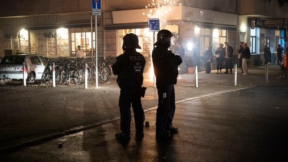 Einsatzkräfte der Berliner Polizei stehen in der Silvesternacht unweit vom Kottbuser Damm. © dpa Foto: Paul Zinken