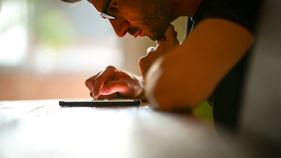 A man uses a smartphone © photocase.de Photo: David-W