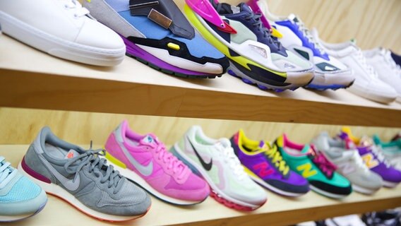 Viele Sneaker stehen im Regal eines Ladens. © dpa Foto: Jörg Carstensen