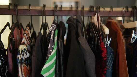 Eine Kleiderstange mit verschiedenen Kleidungsstücken. © NDR Foto: NDR