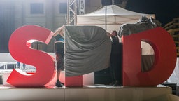Die Buchstaben SPD auf einer Bühne werden zugedeckt. © picture alliance / NurPhoto Foto: Omer Messinger