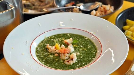 Spinatsuppe mit Kartoffeln und Garnelen in einem Teller serviert. © NDR Foto: Florian Kruck