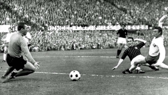 Kurt Hamrin (2.v.r.) erzielt die 1:0-Führung gegen HSV-Torwart Arkoc Özcan (l.), HSV-Abwehrspieler Helmut Sandmann (r.) kommt zu spät. Kurt Hamrin (2.v.r.) erzielt die 1:0-Führung gegen HSV-Torwart Arkoc Özcan (l.), HSV-Abwehrspieler Helmut Sandmann (r.) kommt zu spät. © picture-alliance / dpa Foto: -