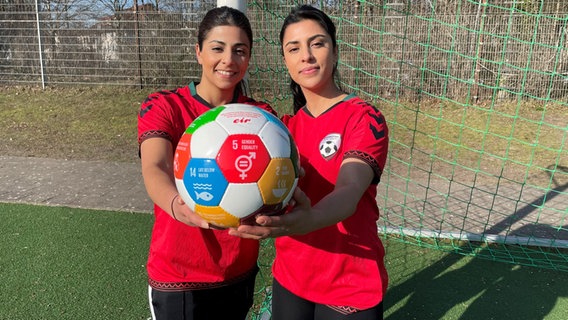 Shabnam und Mariam Ruhin halten Ball mit Aufschrift "gender equality" in die Kamera. © privat 