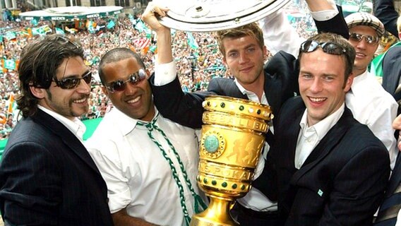 Ailton (2.v.l.) und Werder-Teamkollegen präsentieren 2004 die Meisterschale und den DFB-Pokal auf dem Rathausbalkon. © picture-alliance / dpa/dpaweb 