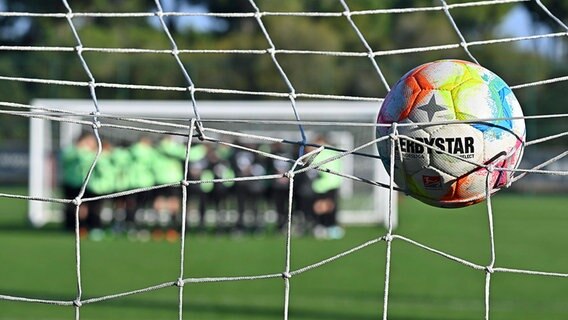 Ein Fußball fliegt ins Tor. © IMAGO / Zink 