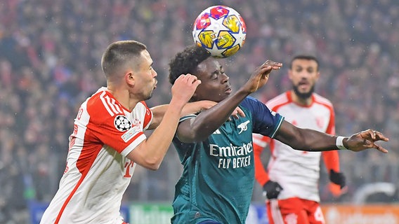 Raphael Guerreiro (l.) vom FC Bayern München im Duell mit Bukayo Saka vom FC Arsenal © IMAGO / Jan Huebner 
