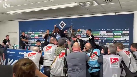 Bierdusche für HSV-Trainer Polzin und Co. bei der Pressekonferenz © NDR 