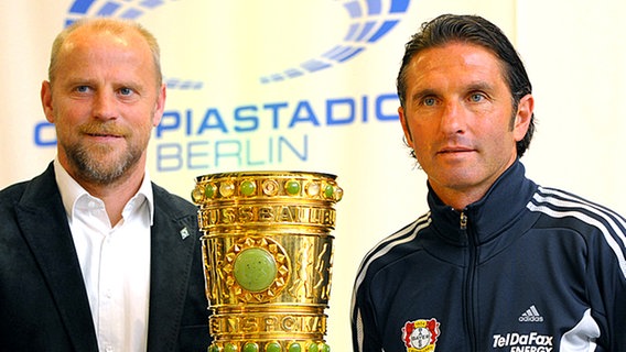 Werder-Trainer Thomas Schaaf (l.) und Leverkusens Coach Bruno Labbadia posieren vor der Pokal-Trophäe. © dpa 