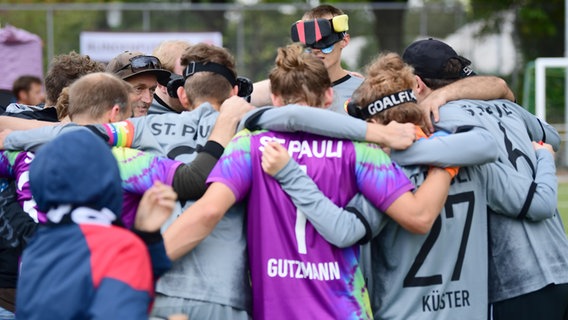 Die Blindenfußball-Mannschaft des FC St. Pauli bildet einen Kreis © Witters Foto: Tay Duc Lam