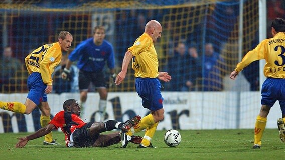 Hannovers Mo Idrissou (am Boden) im Duell mit Braunschweigs Torsten Lieberknecht (l.) und Torsten Sümnich (r.). © imago / Garcia Foto: Garcia