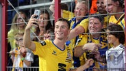 Braunschweigs Yari Otto macht Selfies mit den Eintracht-Fans. © imago/Hübner 