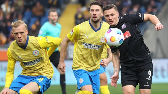 Saulo Decarli und Ermin Bicakcic (v.l.) von Eintracht Braunschweig im Duell mit Erik Engelhardt vom VfL Osnabrück © IMAGO / Susanne Hübner 