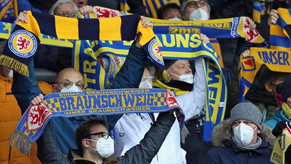 Fans von Eintracht Braunschweig halten Schals hoch. © IMAGO / regios24 