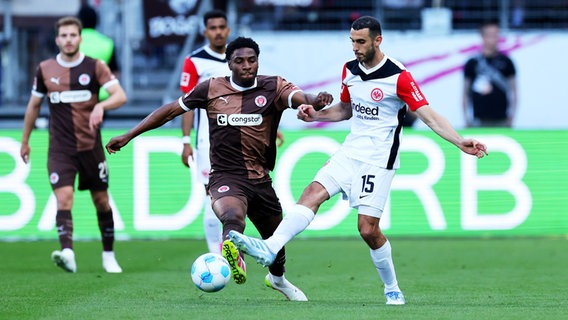 St. Paulis Oladapo Afolayan (l.) und Frankfurts Ellyes Skhiri kämpfen um den Ball. © Witters/JoergHalisch 