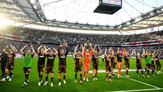 St. Paulis Spieler jubeln und bedanken sich bei den mitgereisten Fans. © IMAGO / Eibner 
