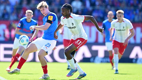 Kiels Lasse Rosenboom (l.) und Freiburgs Jordy Makengo kämpfen um den Ball. © Witters/LeonieHorky 