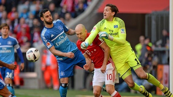 Hamburgs Torwart René Adler (r.) und Mergim Mavraj (l.) kämpfen gegen Münchens Arjen Robben um den Ball. © dpa - Bildfunk Foto: Andreas Gebert