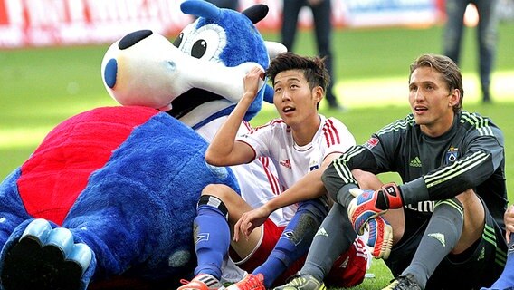 HSV-Maskottchen "Dino", Heung Min Son (M.) und Rene Adler vor der HSV-Fankurve © imago sportfotodienst Foto: imago sportfotodienst