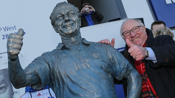 Uwe Seeler steht neben der Bronzestatue von Ex-Masseur Hermann Rieger © dpa Foto: Axel Heimken