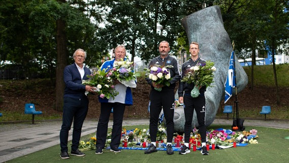 Bernd Wehmeyer (l-r), Club-Manager beim Fußball-Zweitligisten Hamburger SV, Horst Hrubesch, Nachwuchsdirektor im Nachwuchsleistungszentrum des Hamburger SV, Trainer Tim Walter und Spieler Sebastian Schonlau, stehen während eines Medientermins anlässlich des Todes von Uwe Seeler am Volksparkstadion © picture alliance/dpa | Daniel Reinhardt 