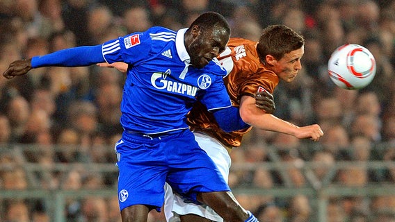 Schalkes Hans Sarpei (l.) und St. Paulis Max Kruse gehen zum Kopfball. © dpa 