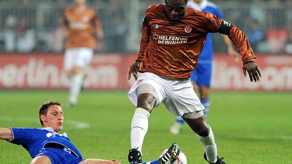 St. Paulis Gerald Asamoah (r.) wird von Schalkes Benedikt Höwedes vom Ball getrennt. © dpa 