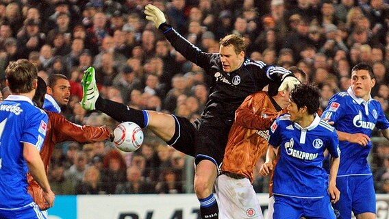 Schalkes Torwart Manuel Neuer (M.) und St. Paulis Ralph Gunesch (3.v.r.) kämpfen um den Ball. © dpa 